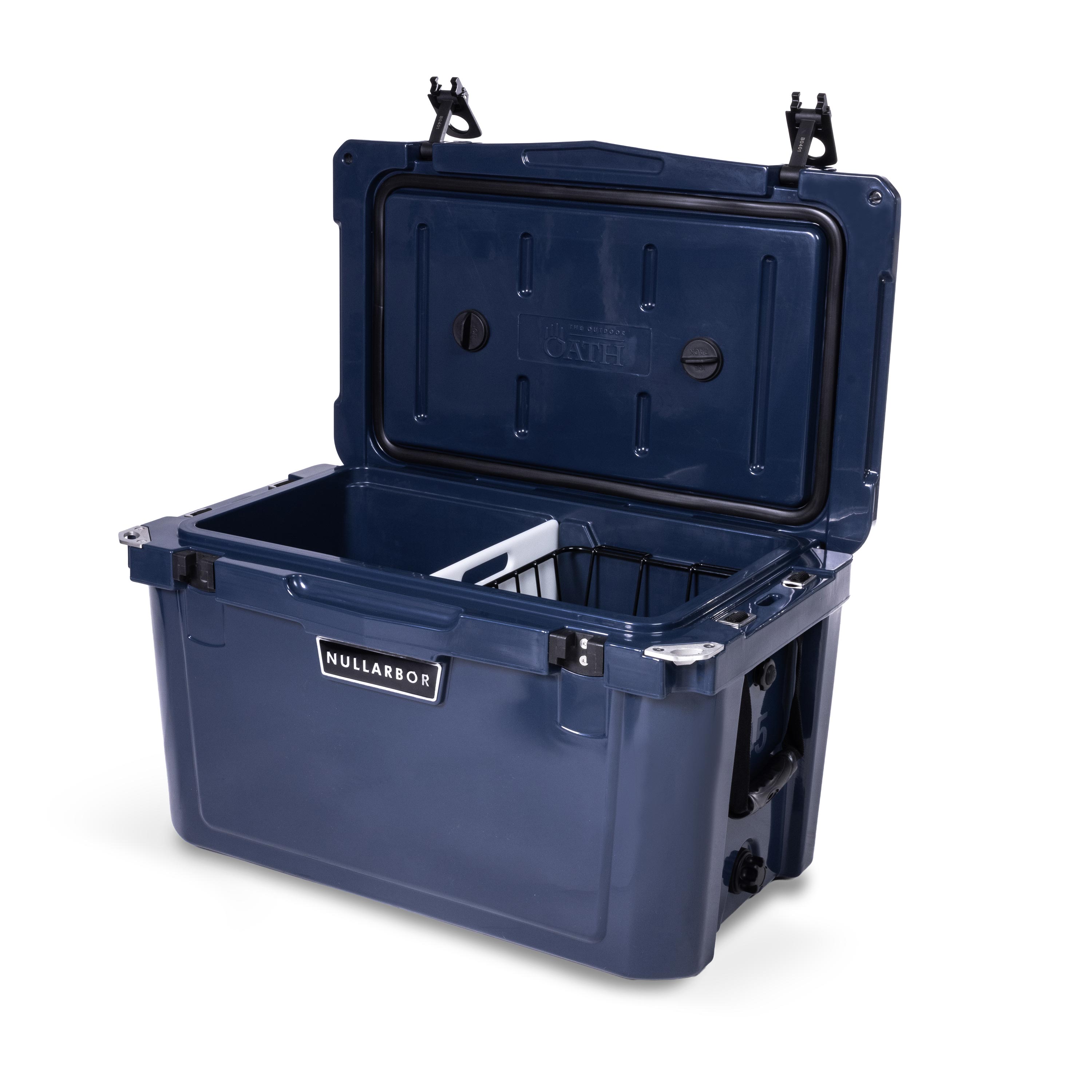 Right side 45 degree view of open medium 43 litre blue cooler box with side handle, 2 easy lock latches on lid, bottle openers on each corner. Pressure release valve and leak proof easy flow drainage plug on side. Food divider / chopping board and wire food basket inside.
