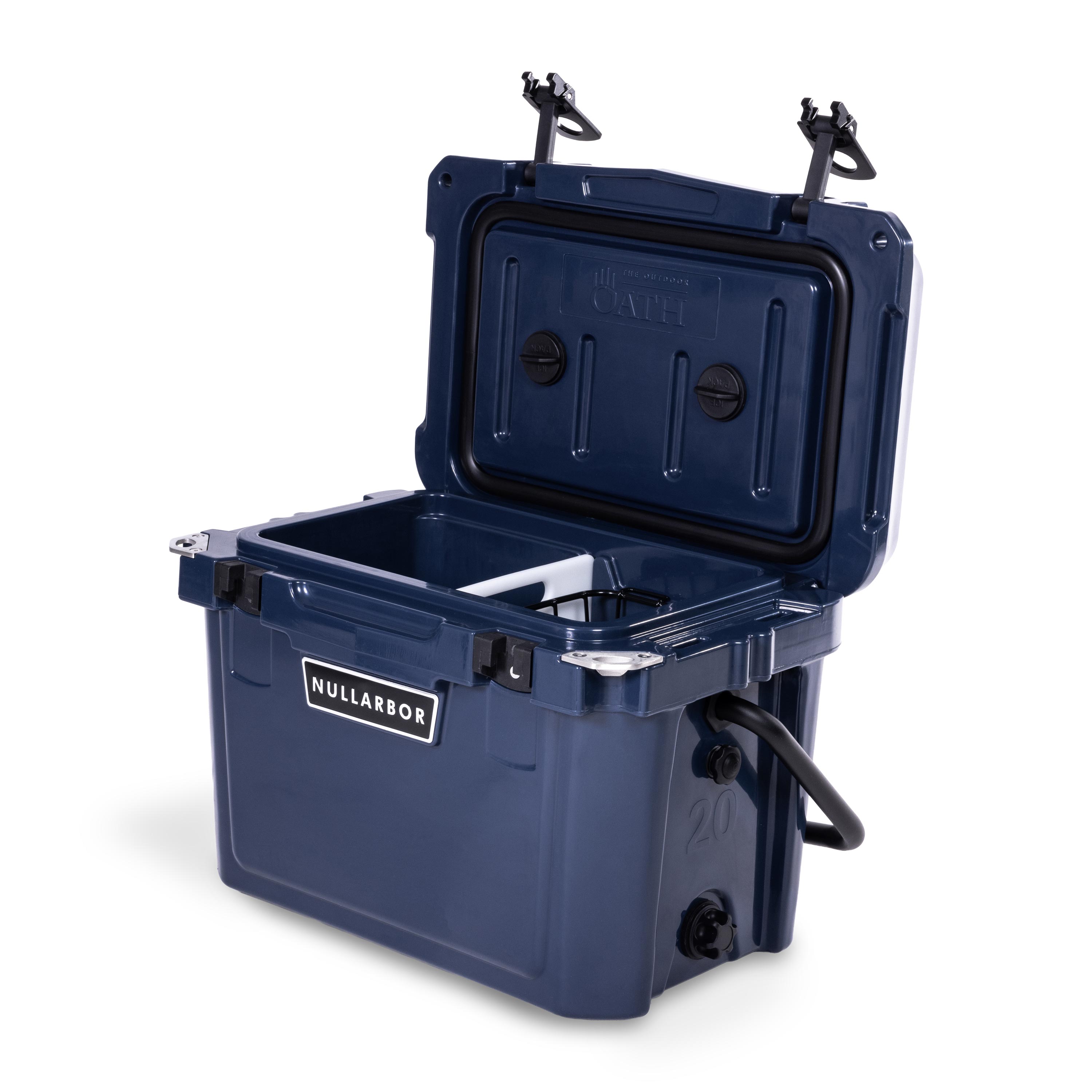 Right side 45 degree view of open small 19 litre blue cooler box with side handle, 2 easy lock latches on lid, bottle openers on each corner. Pressure release valve and leak proof easy flow drainage plug on side. Food divider / chopping board and wire food basket inside.